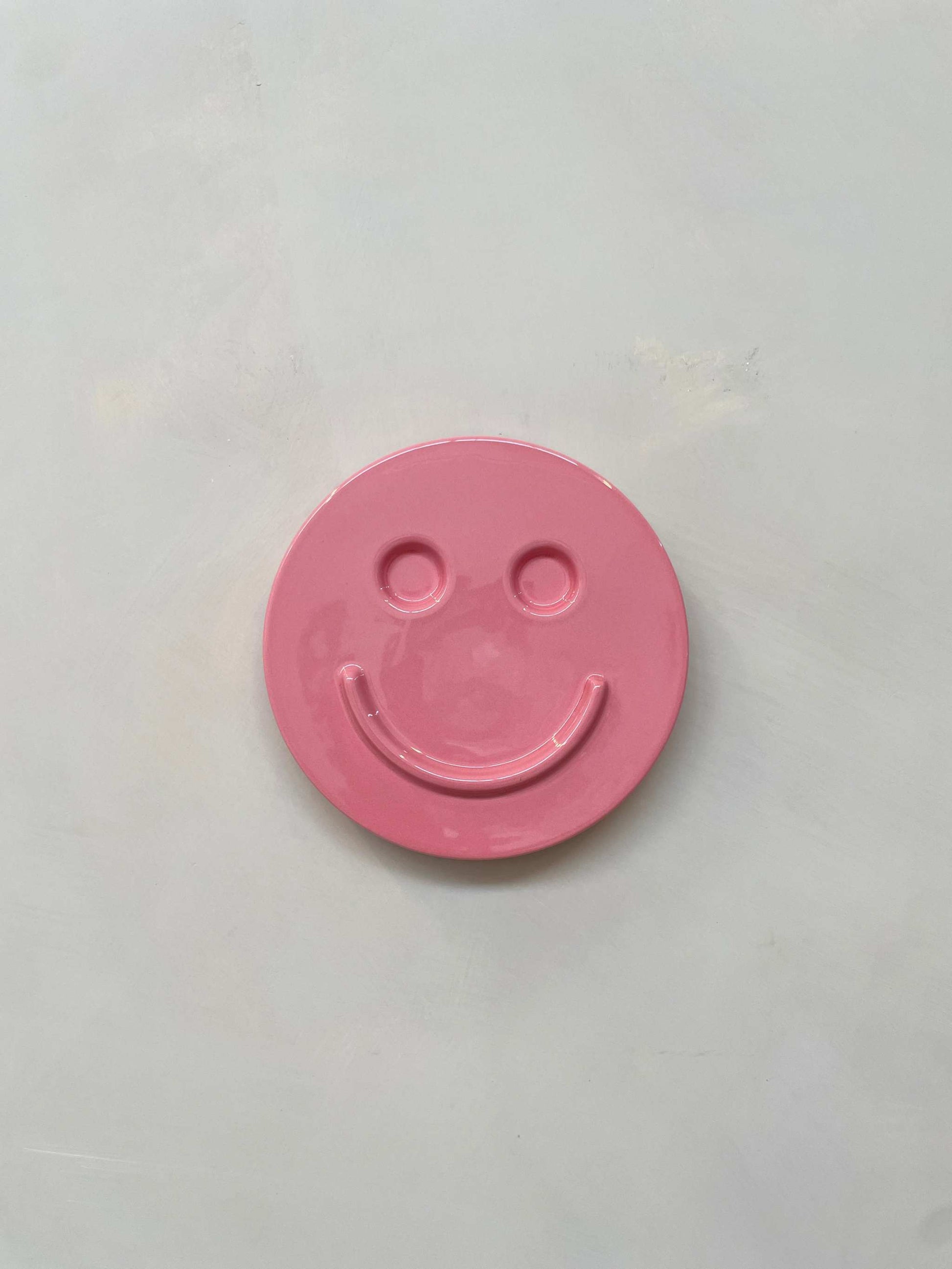 Pink 'HAPPY' ceramic artwork by Edith Beurskens, handcrafted smiley face.